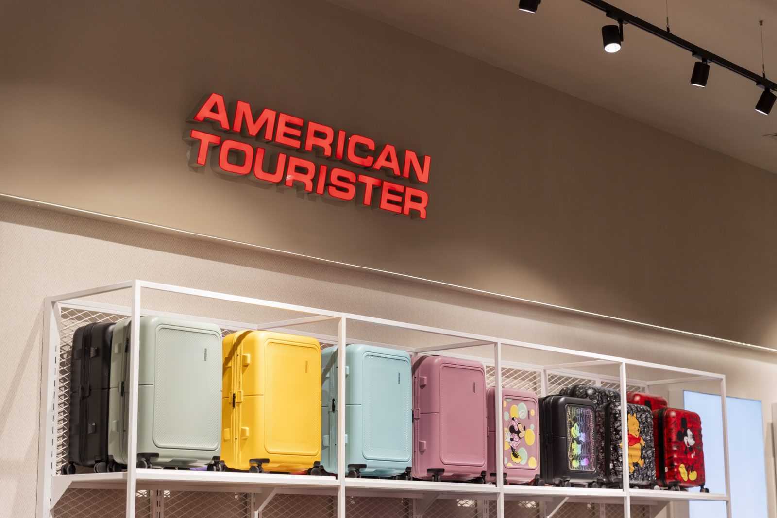 American Tourister luggage display with colorful suitcases.