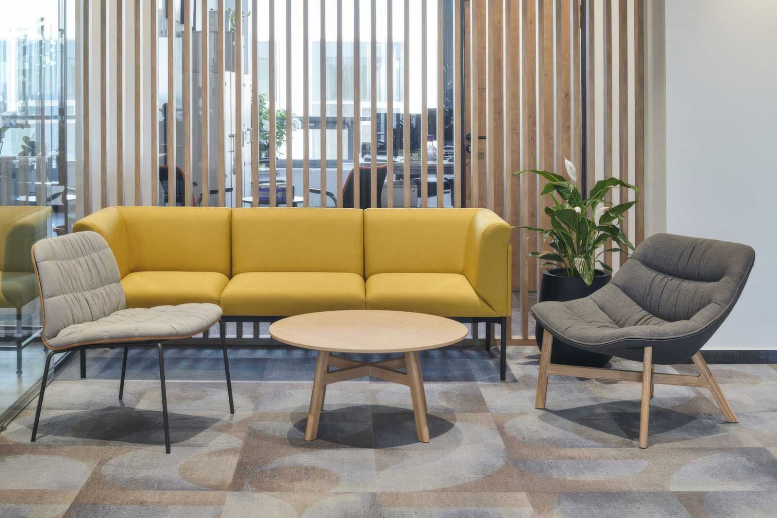 Modern yellow sofa and chairs in a stylish office lounge.