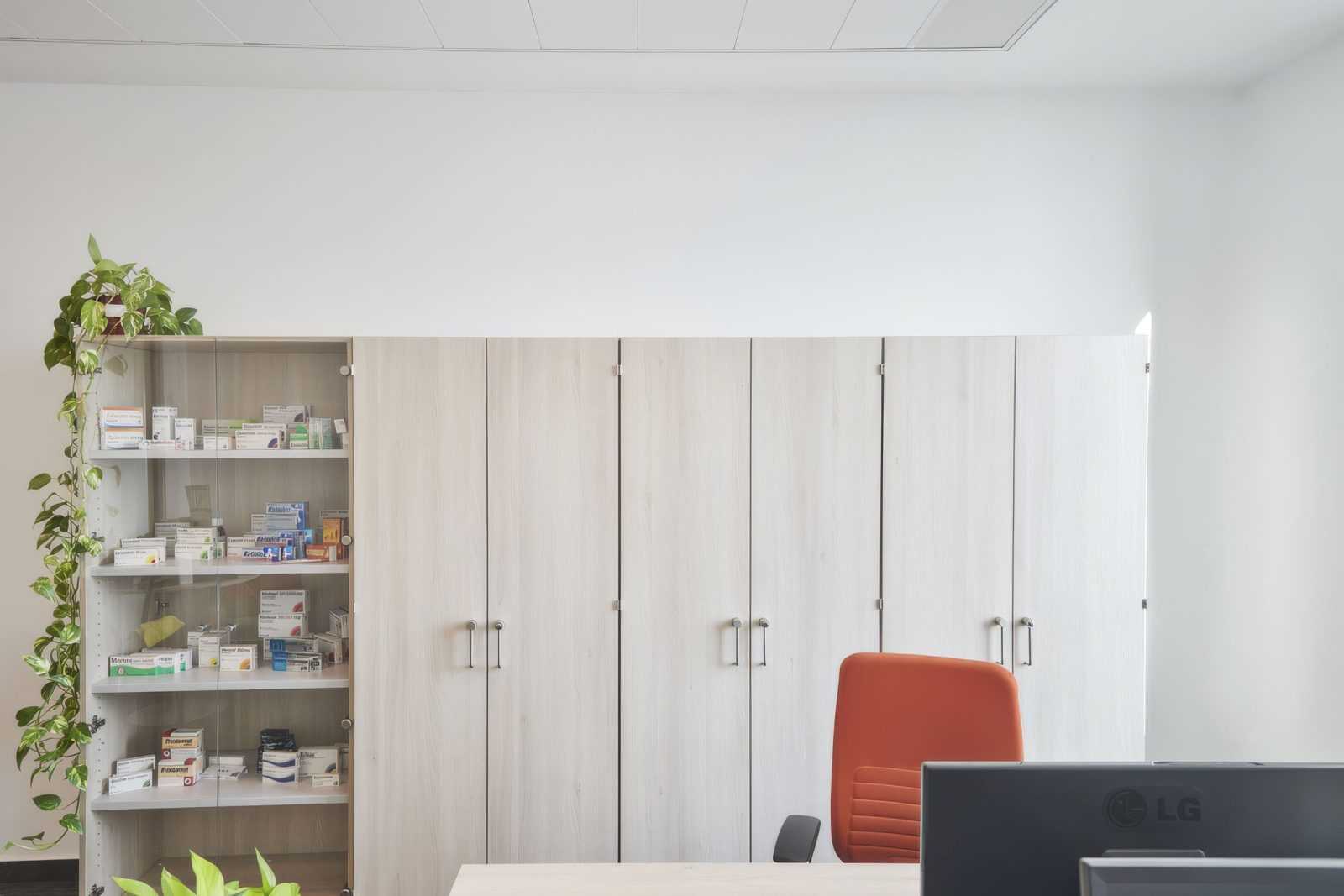 Modern pharmacy interior with medicine shelves and orange chair.