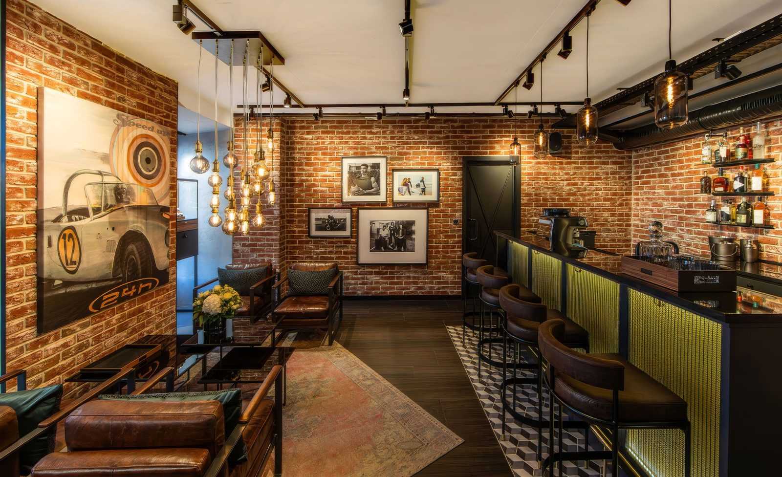 Industrial style bar with brick walls and vintage car artwork.