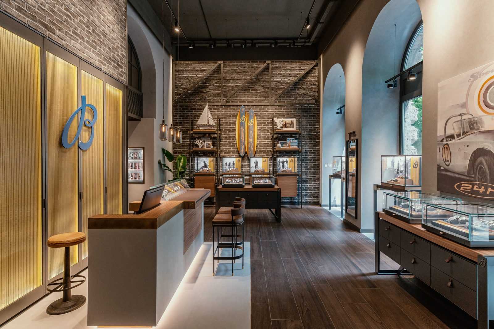 Modern luxury watch store interior with wooden floors and brick walls.