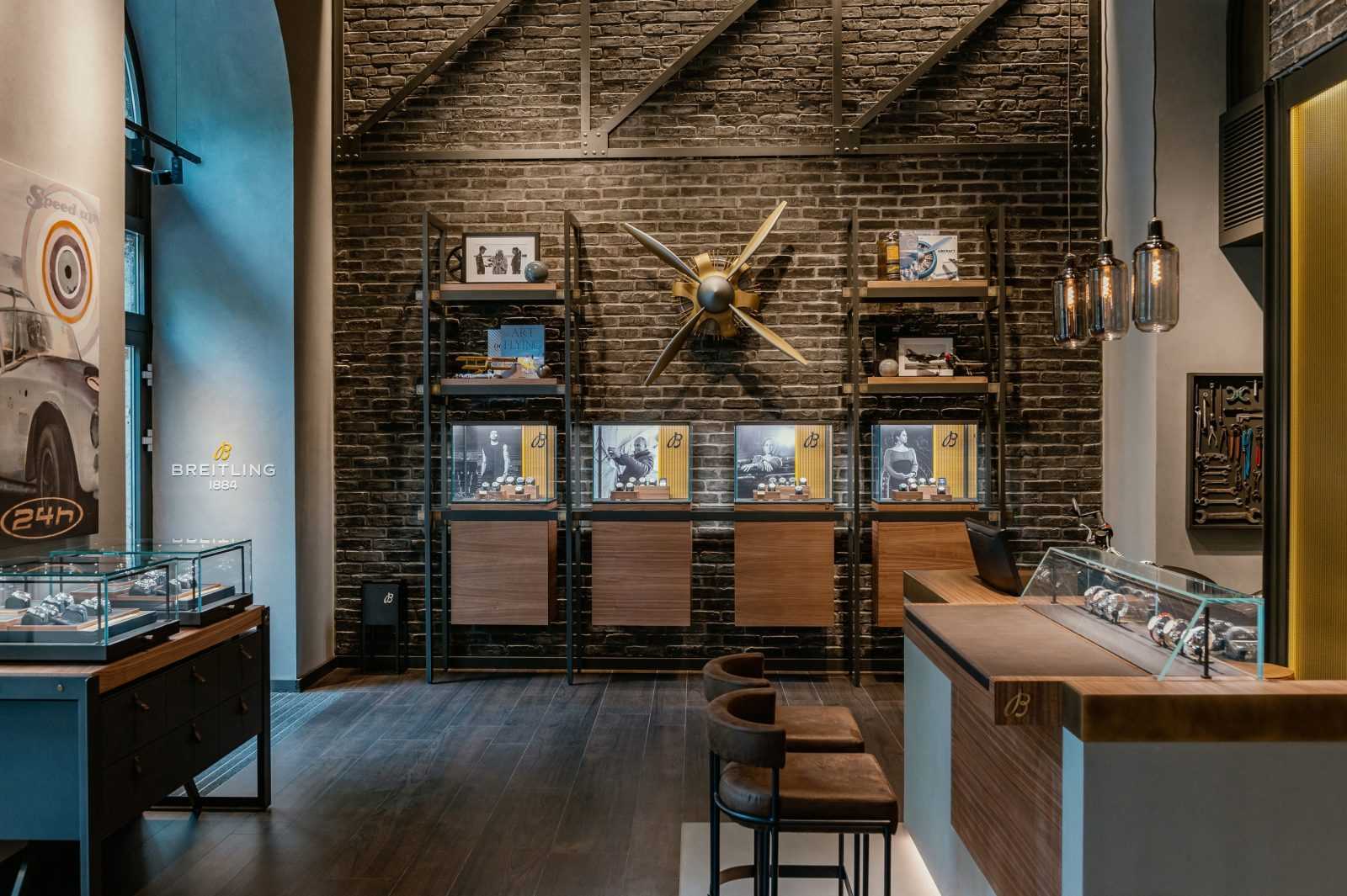 Luxury Breitling watch store interior with brick walls and display cases.
