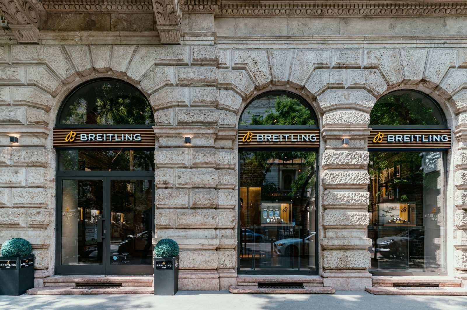 Breitling luxury watch store front with arched windows and stone facade.