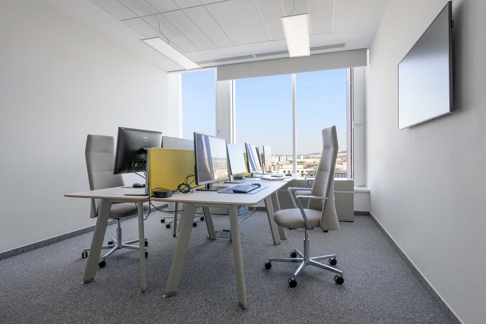 Modern office with computers and city view.