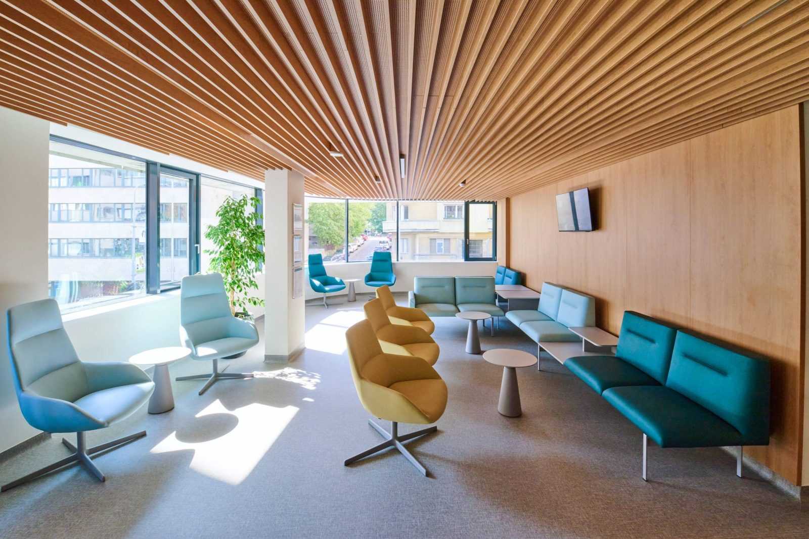 Modern waiting area with wooden ceiling and colorful seating.