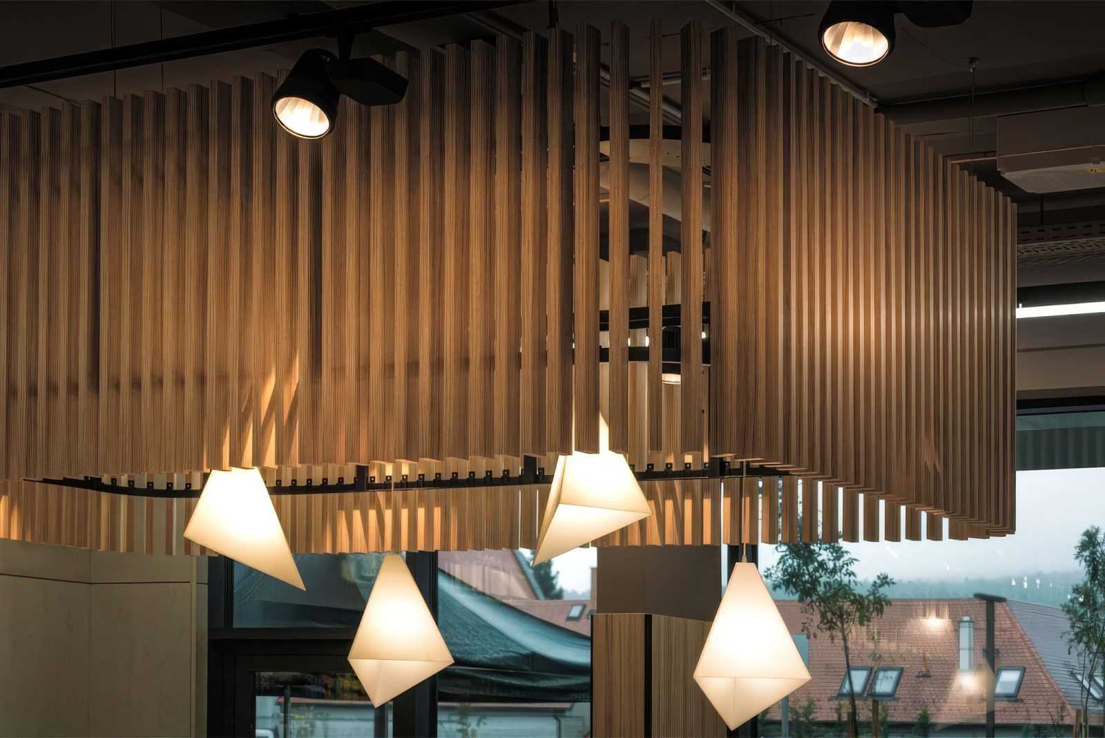 Modern wooden slat ceiling with hanging pendant lights in a stylish interior.
