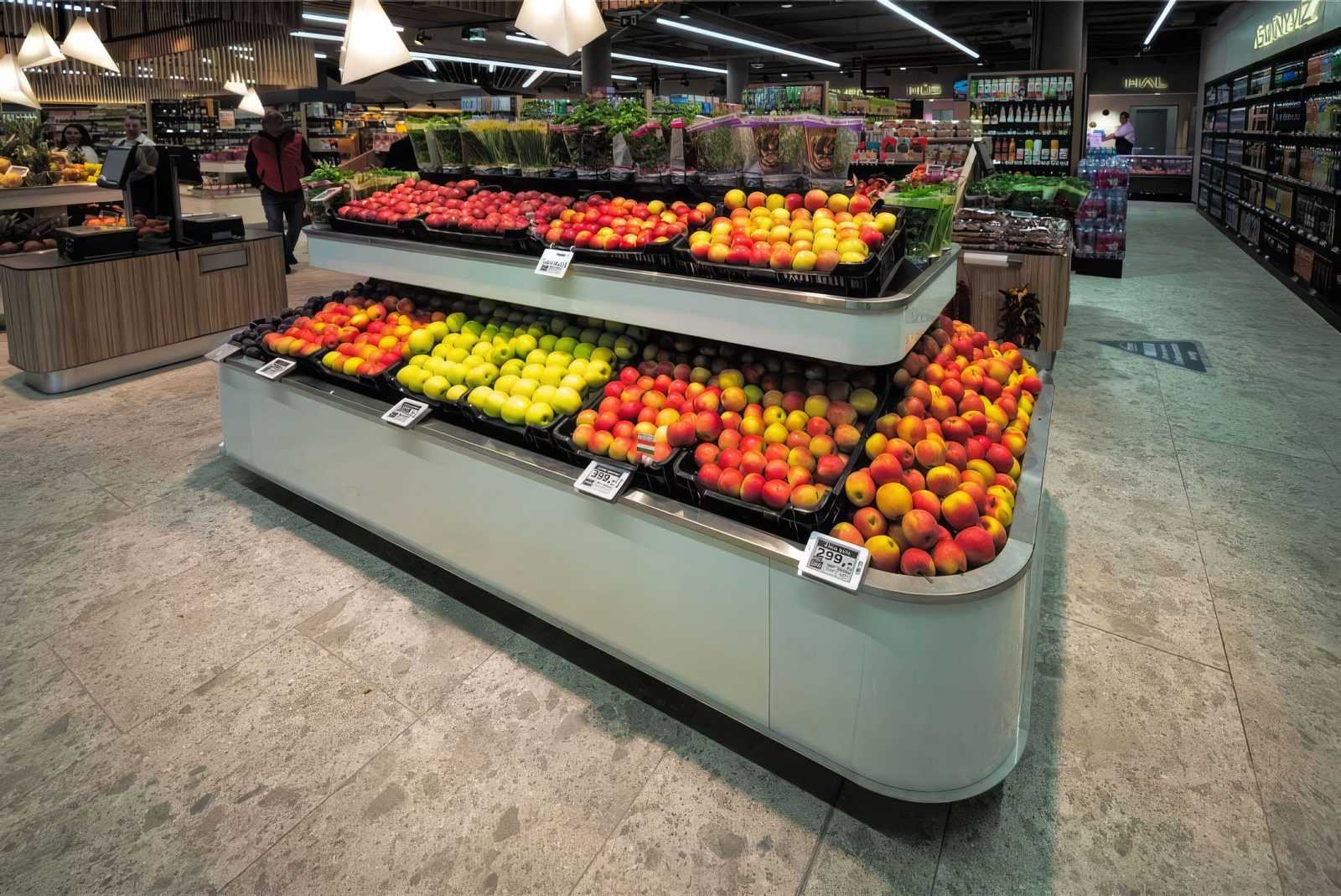 Fresh apples and fruits displayed in a modern supermarket aisle.