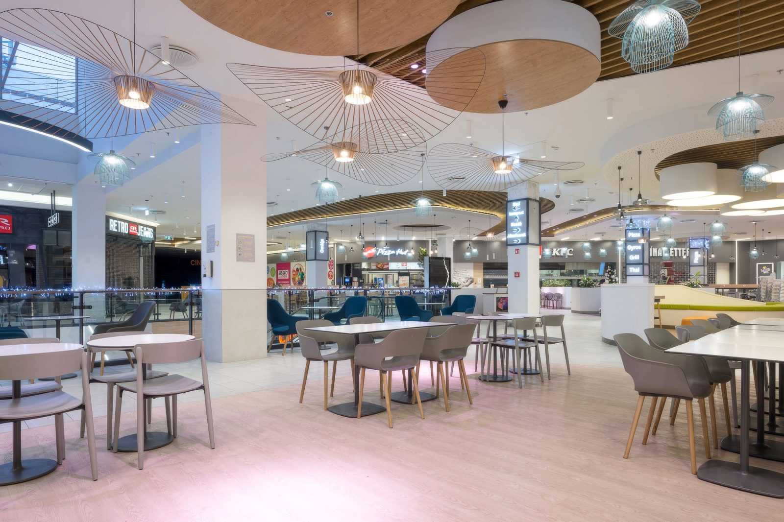 Modern food court with stylish lighting and seating at Megaholz shopping center.