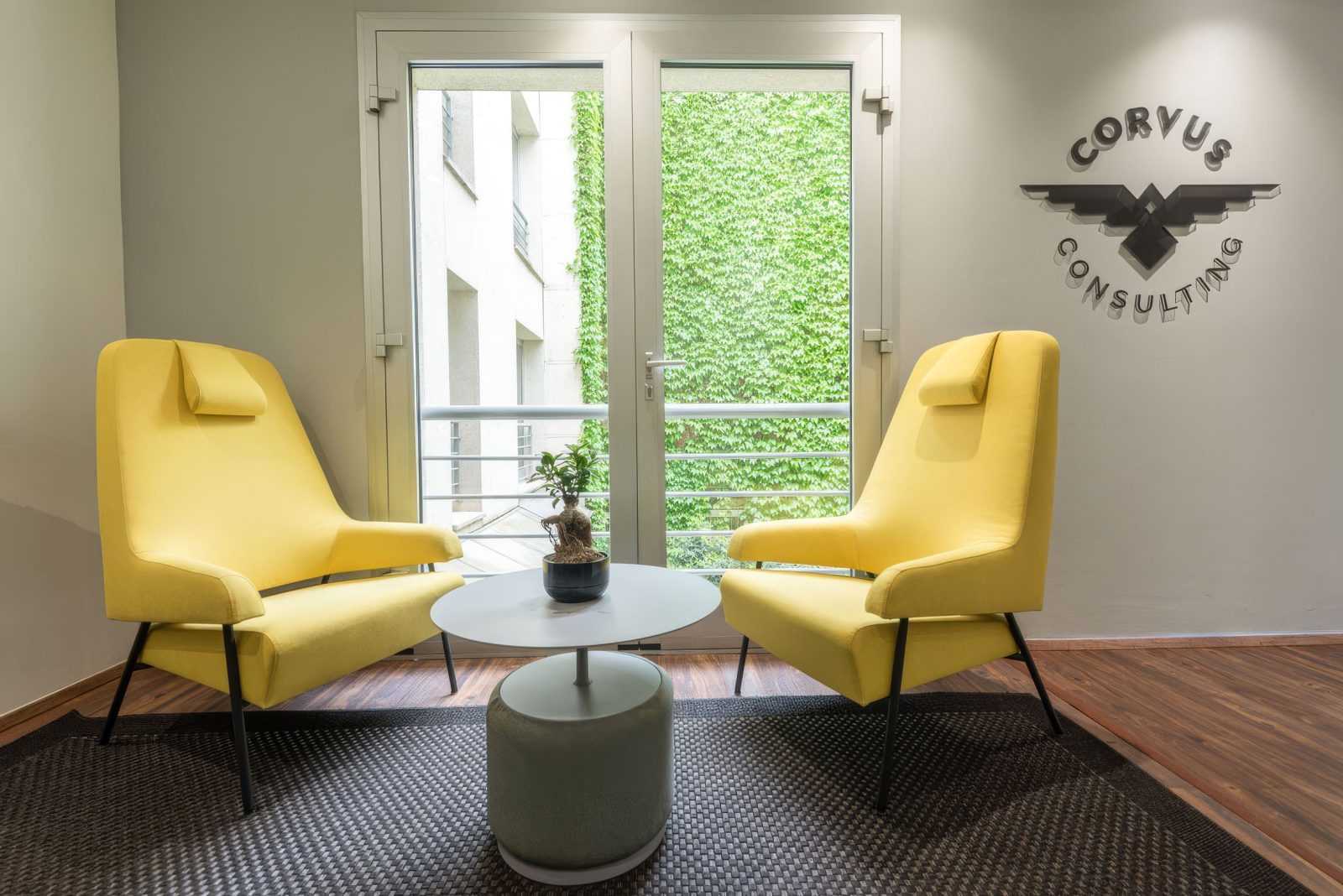 Modern yellow chairs in a corporate lounge with Corvus Consulting logo.