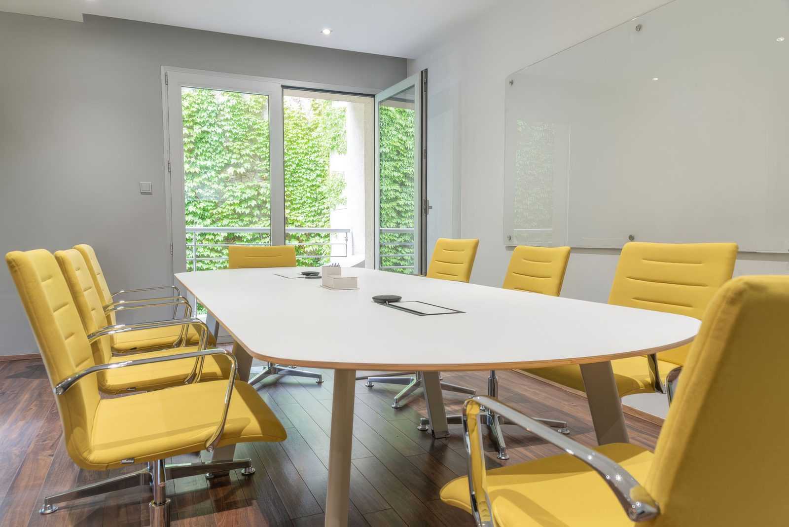 Modern conference room with yellow chairs and large windows.