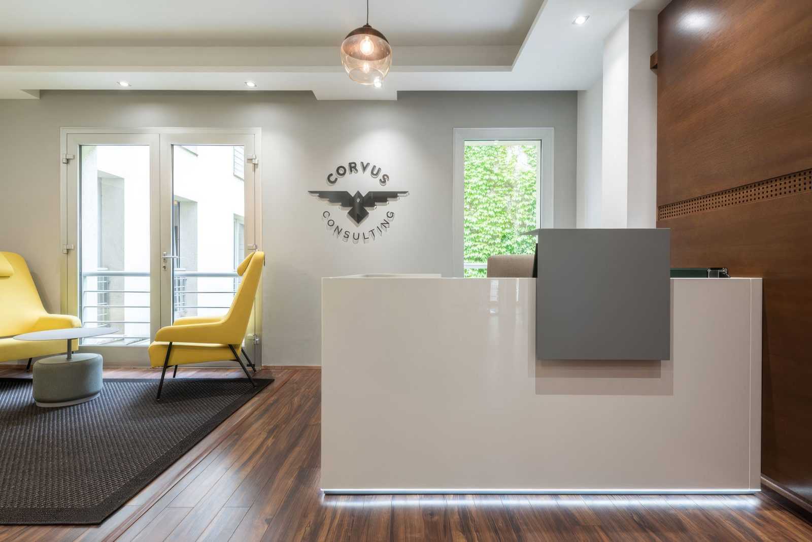 Modern office reception with Corvus Consulting logo and yellow chairs.