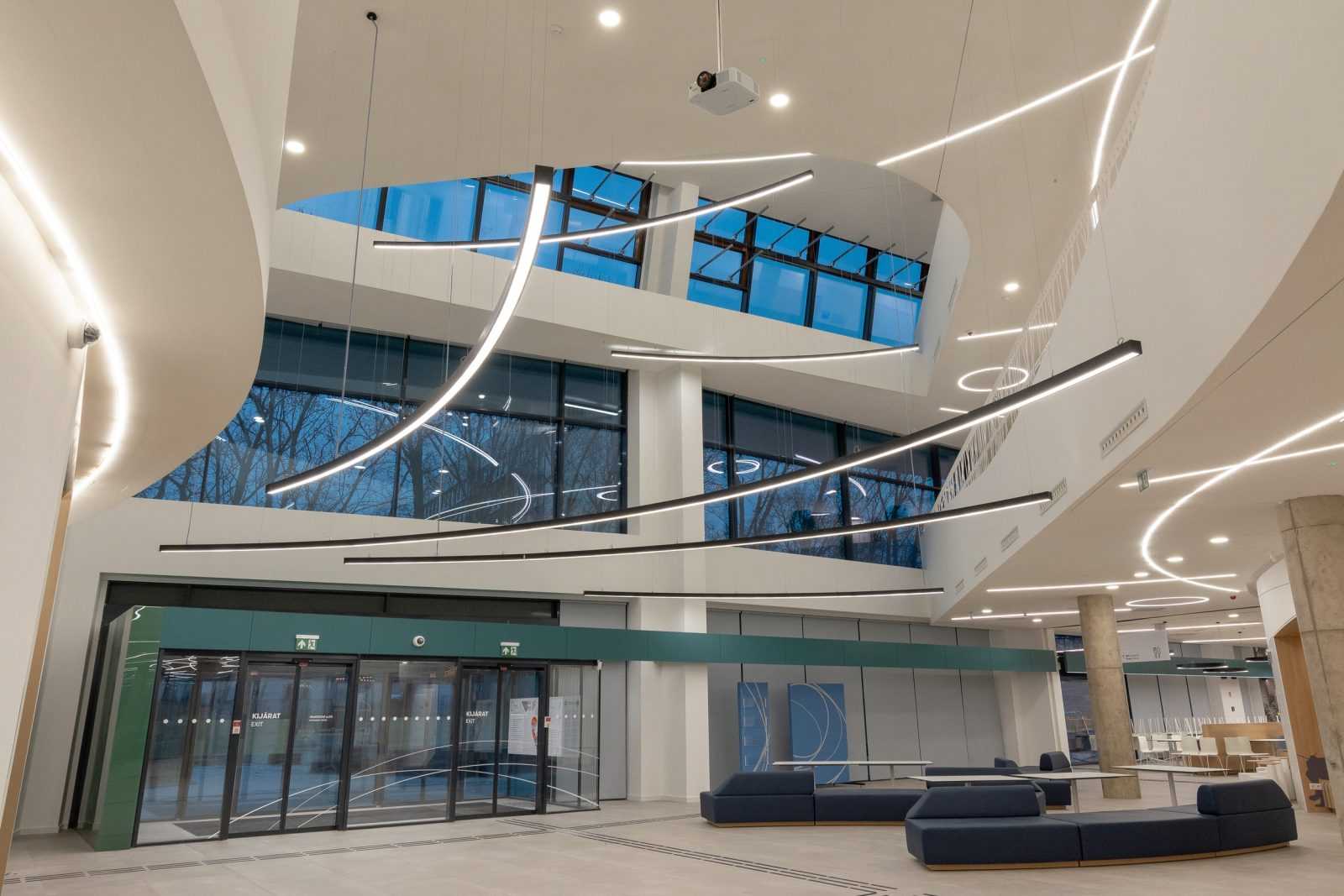 Modern office lobby with curved lighting and glass windows.