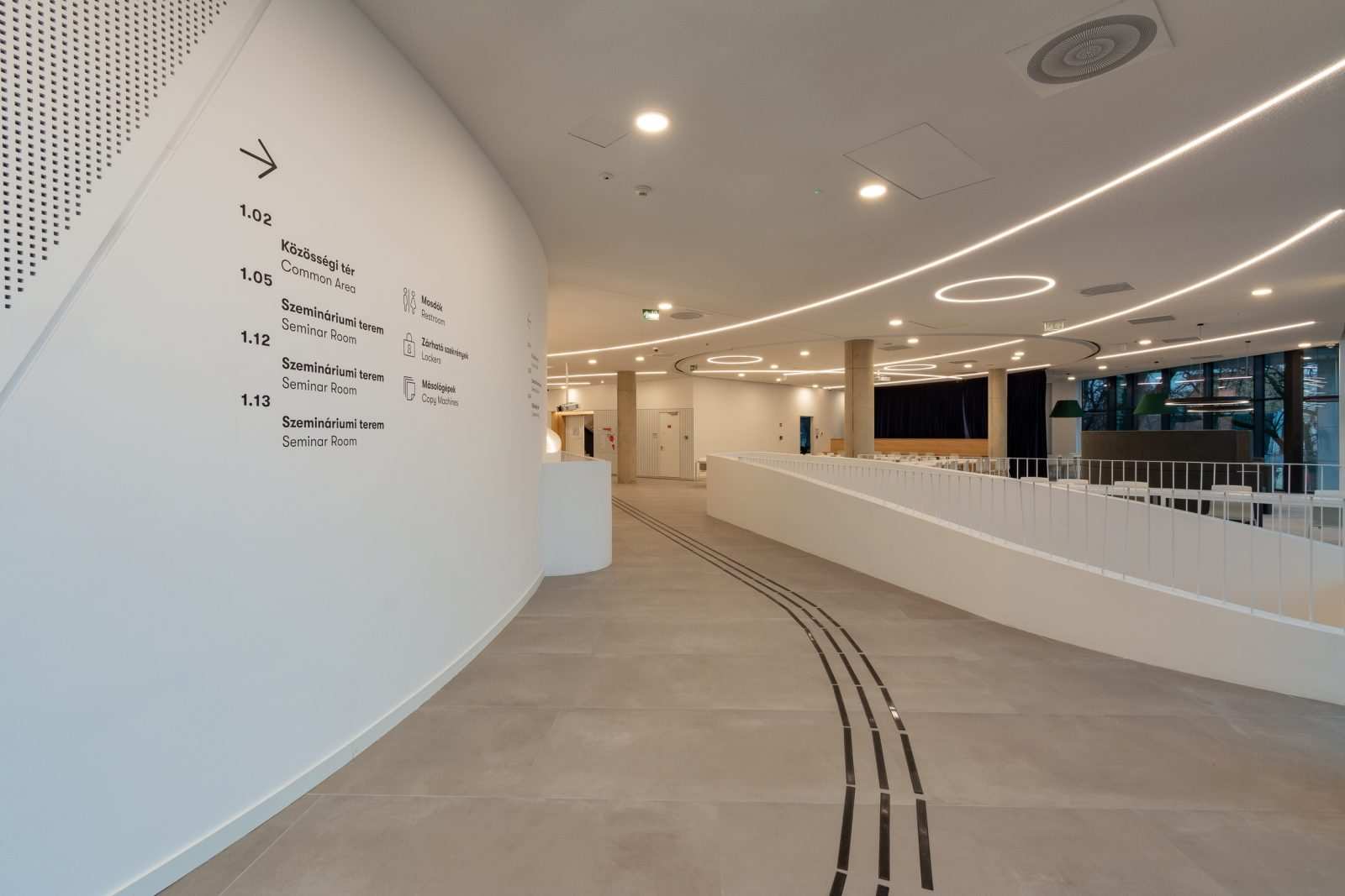 Modern hallway with directional signs to seminar rooms and common area at Megaholz.
