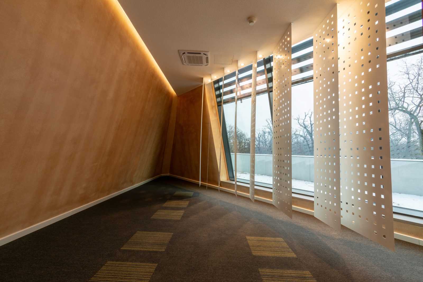 Modern hallway with wooden walls and perforated metal screens at Megaholz.