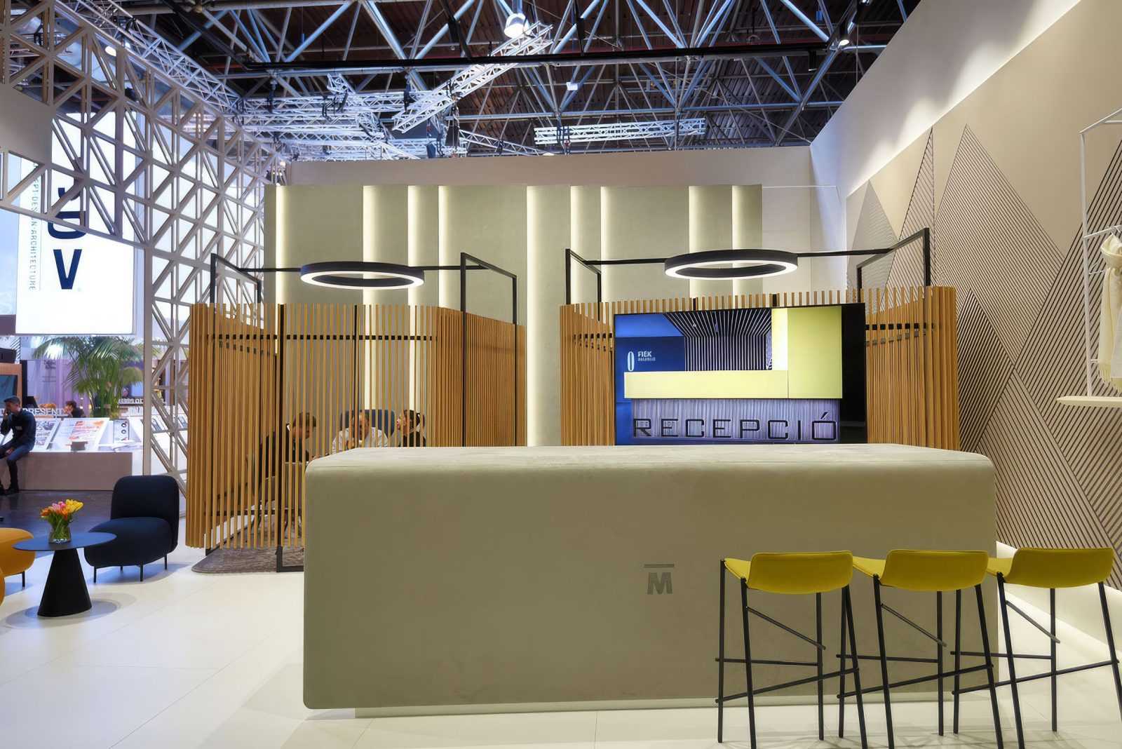 Modern reception area with wooden partitions and yellow stools at Megaholz exhibition.