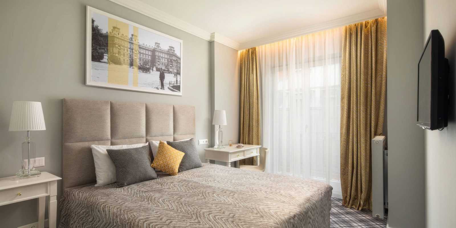 Cozy hotel room with elegant decor and large window.