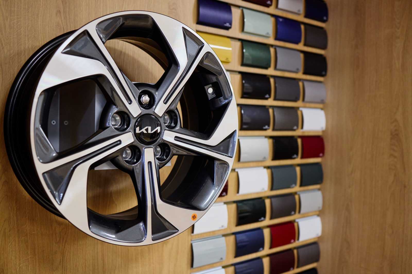 Kia alloy wheel with color swatches in car customization shop.