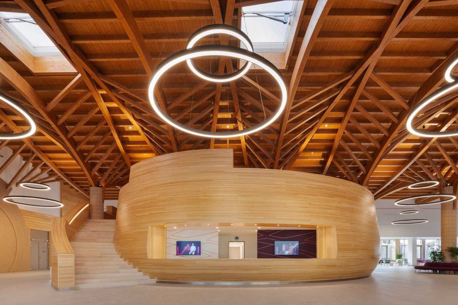 Modern wooden interior with circular lights and curved reception desk.