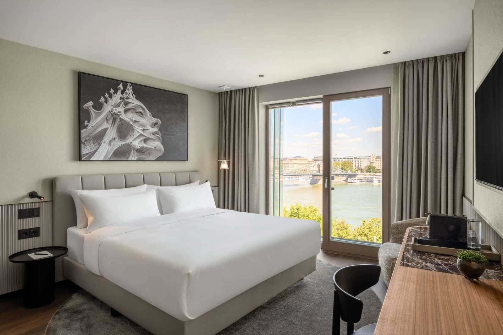 Modern hotel room with river view and contemporary art.