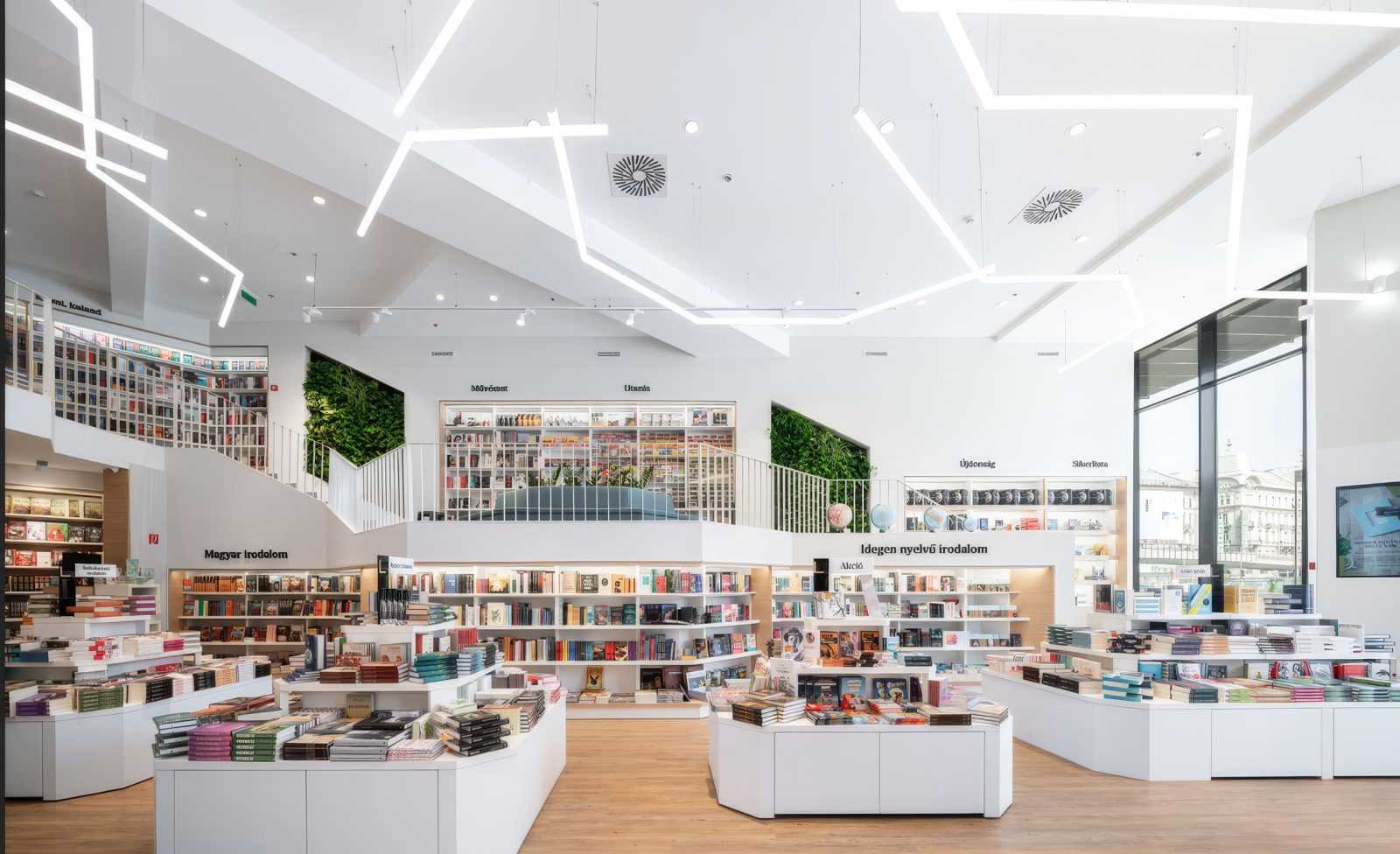 Modern bookstore interior with white shelves, books, and geometric lighting.