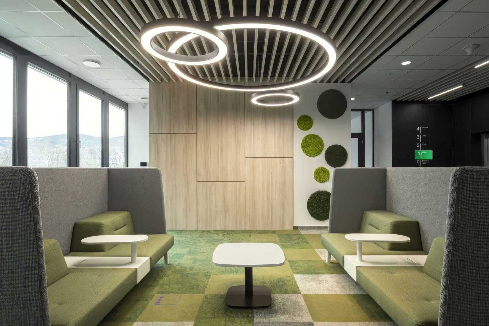 Modern office lounge with green seating and circular lighting.