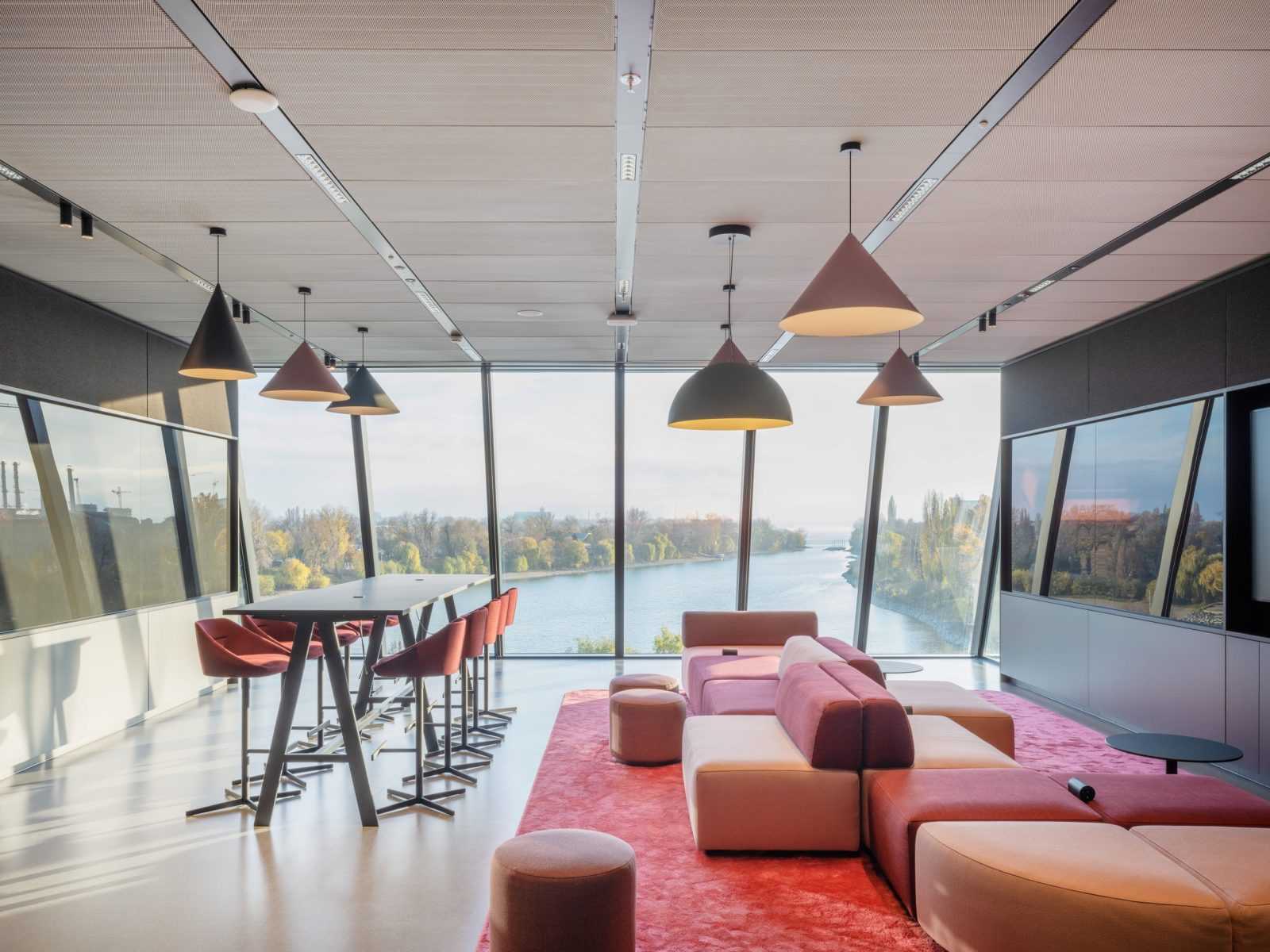 Modern office lounge with river view and stylish furniture.
