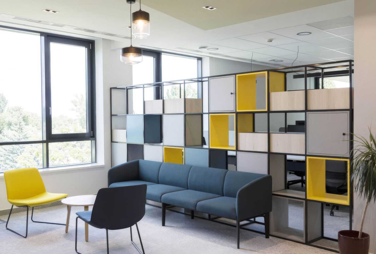 Modern office lounge with colorful modular storage and blue sofa.