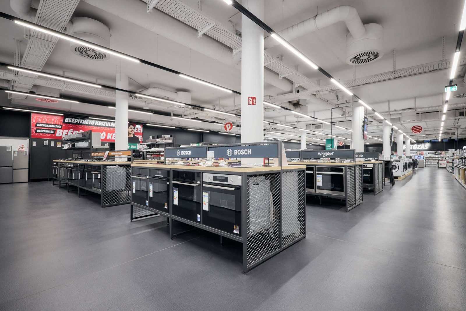 Modern appliance store interior with Bosch and Whirlpool ovens on display.