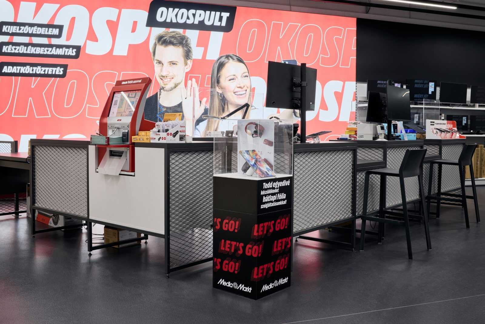 Media Markt store interior with OKOSPULT service counter and customer service desks.
