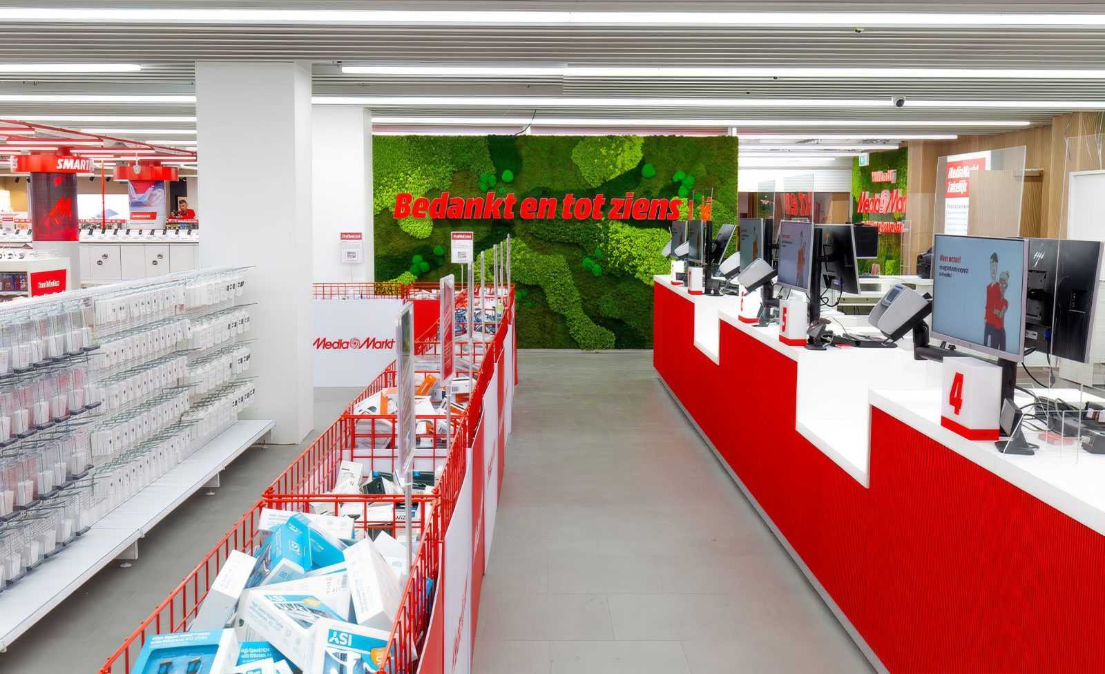 MediaMarkt store interior with checkout counters and green wall.