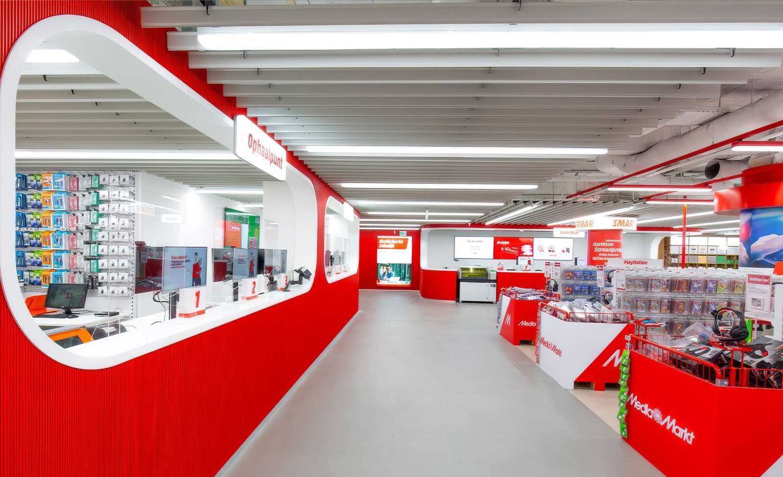 Modern MediaMarkt store interior with red and white design, showcasing electronics and gaming sections.