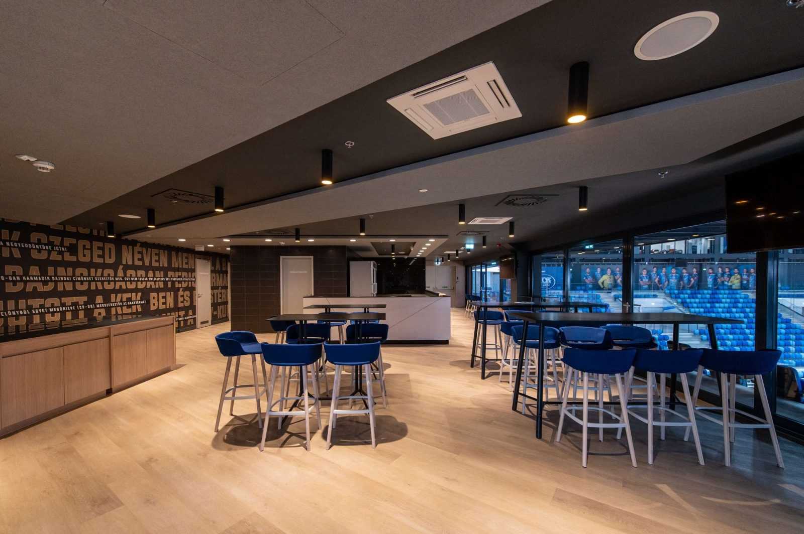 Modern sports bar with blue stools and stadium view at Megaholz.