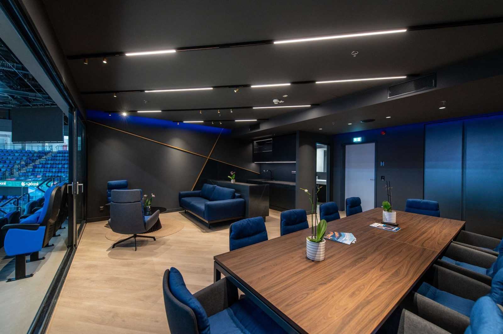 Modern luxury lounge with blue seating and wooden table at Megaholz.