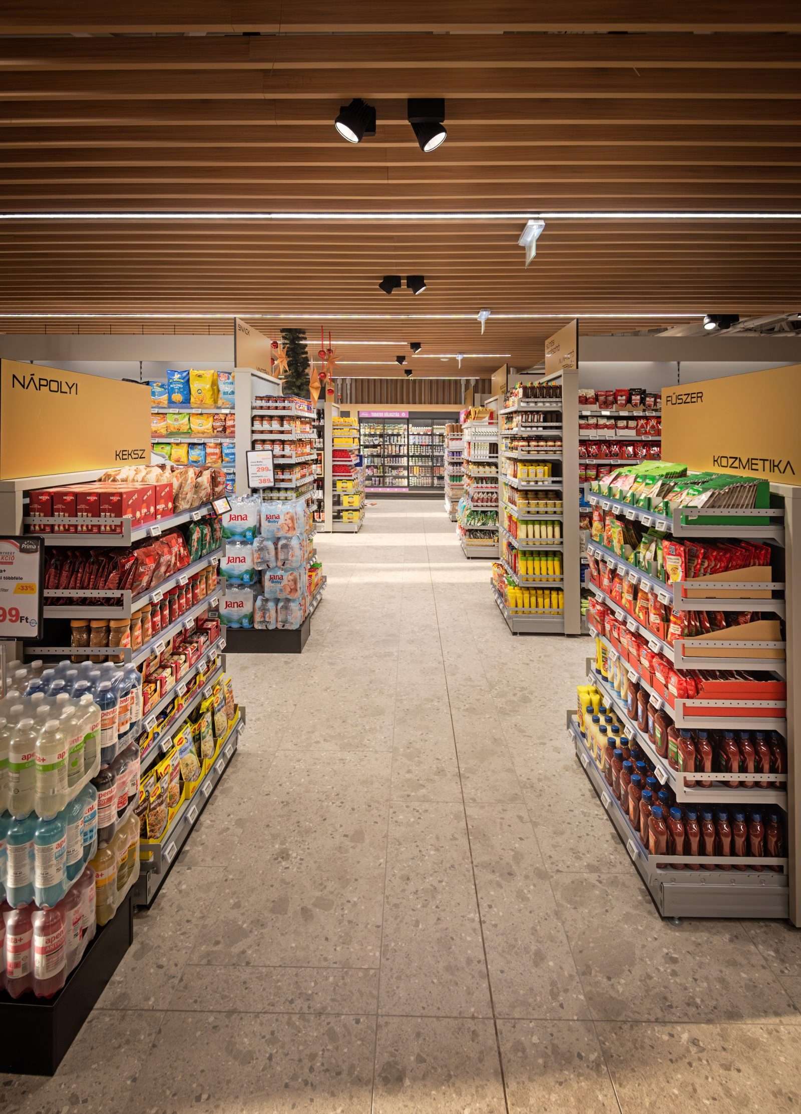 Modern supermarket aisle with neatly stocked shelves and wooden ceiling.