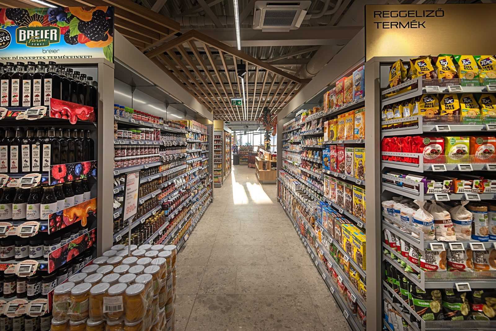 Modern supermarket aisle with breakfast cereals and fruit syrups.