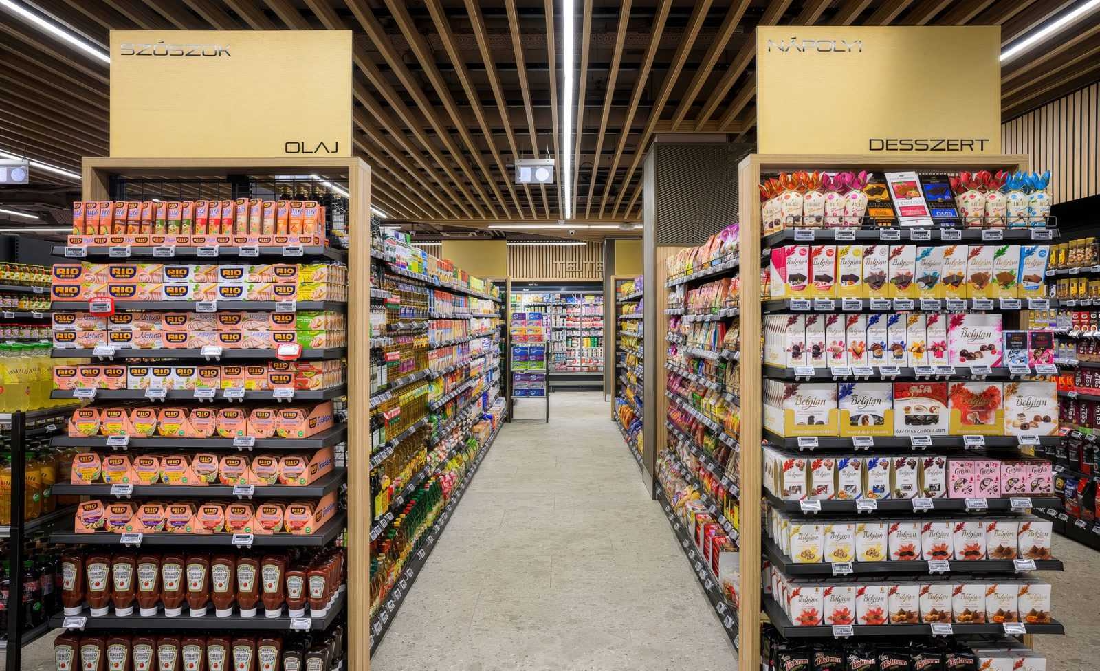 Modern supermarket aisle with sauces and desserts shelves.