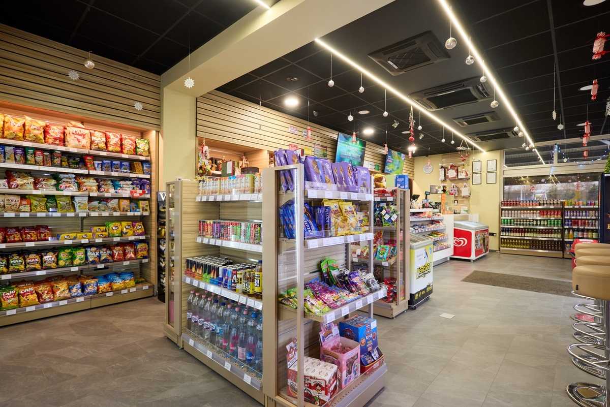 Modern convenience store interior with snack shelves and beverage coolers.