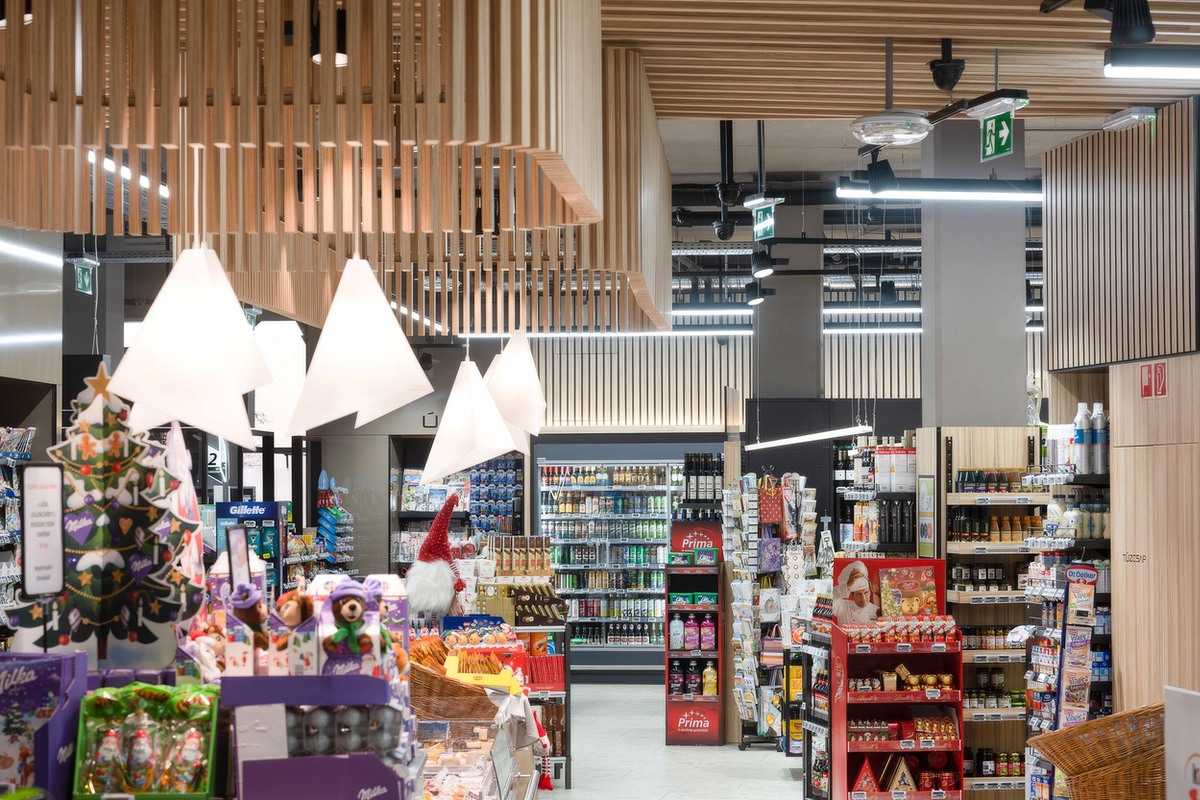 Modern supermarket interior with wooden ceiling and festive decorations.