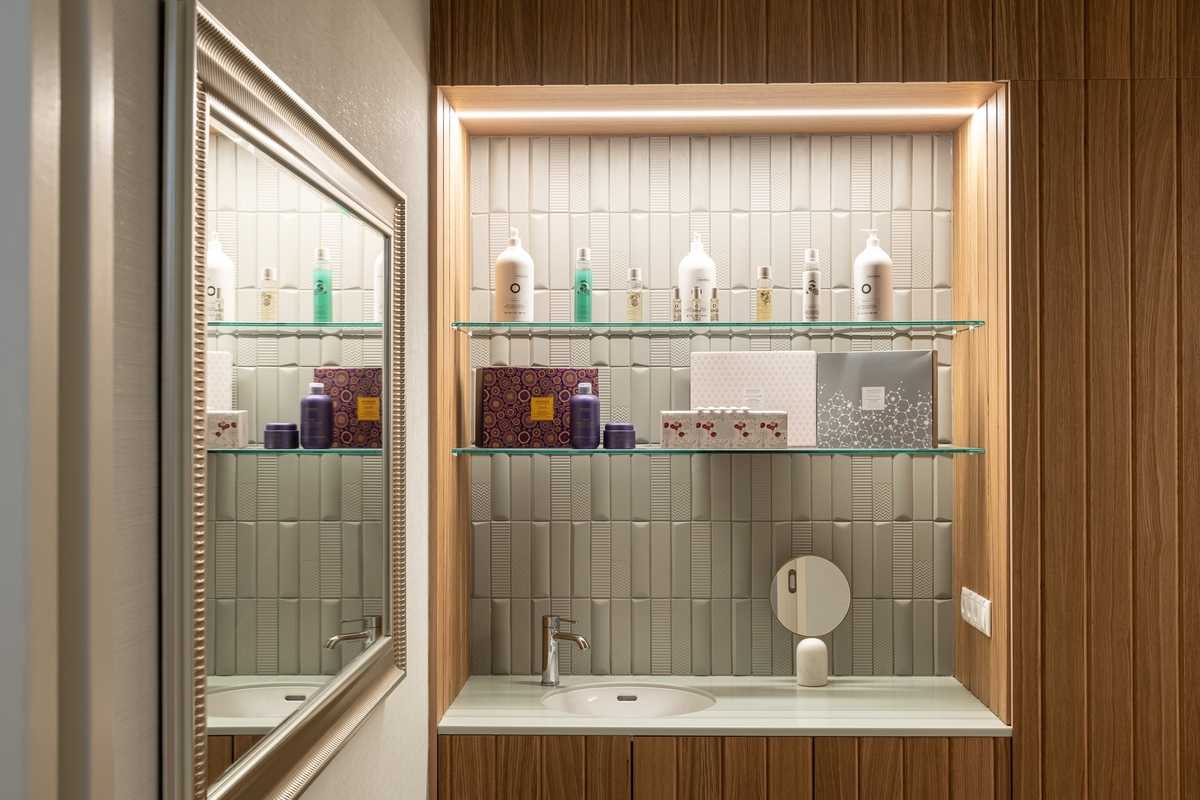 Modern bathroom vanity with glass shelves and wooden accents.