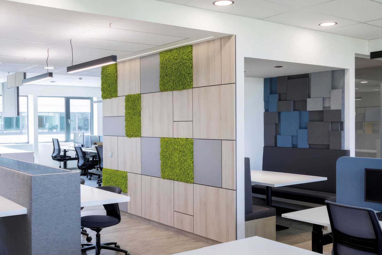 Modern office interior with green moss wall panels and wooden accents.