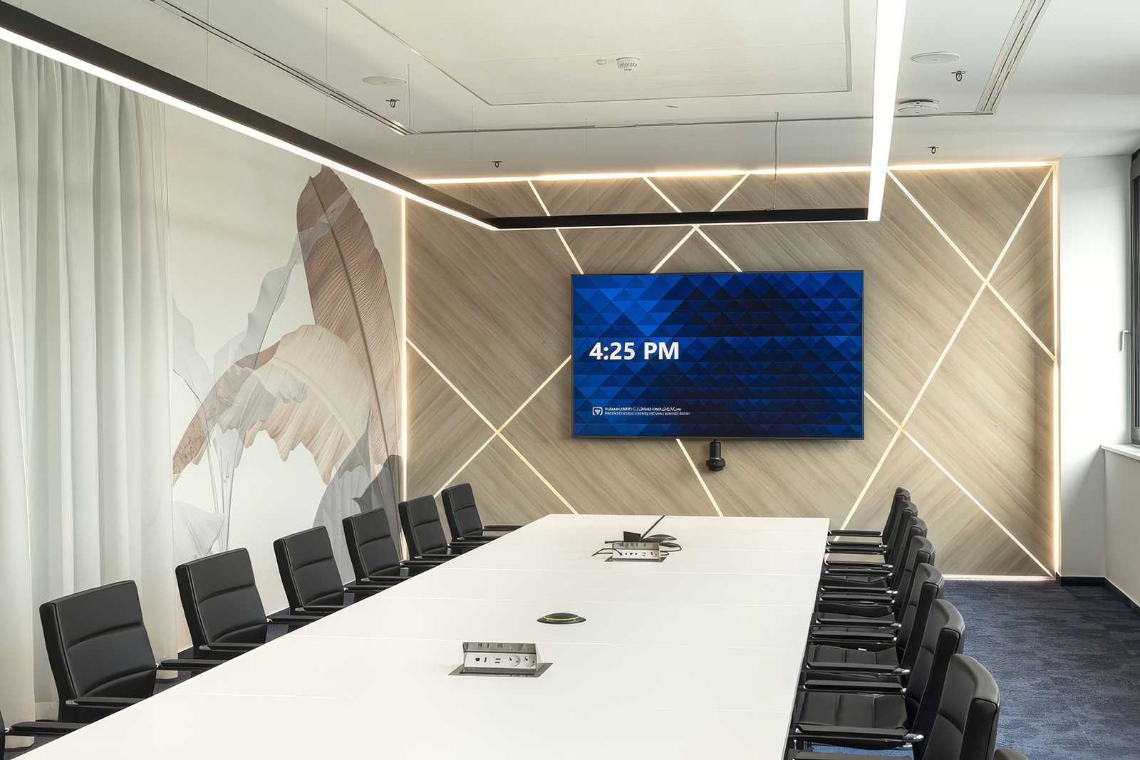 Modern conference room with wooden wall, large screen, and black chairs.