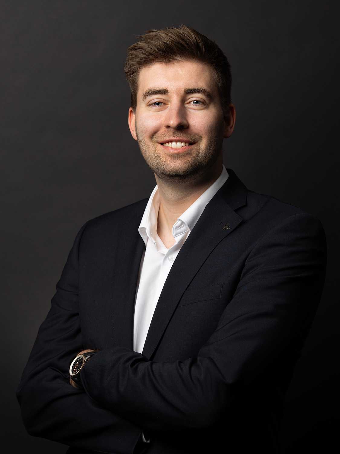 Professional man in suit smiling for Megaholz company profile.