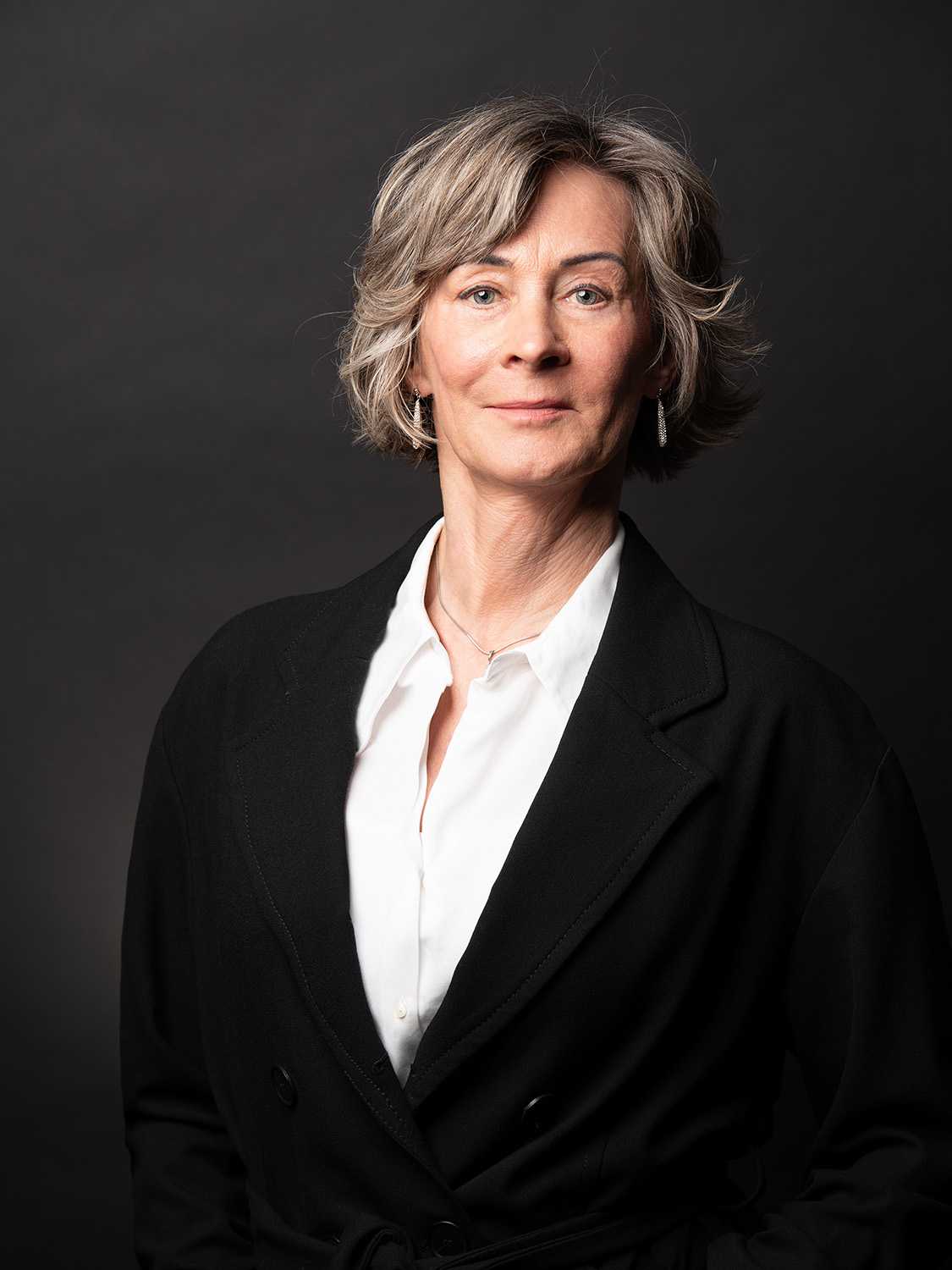 Professional portrait of a woman in black blazer and white shirt.