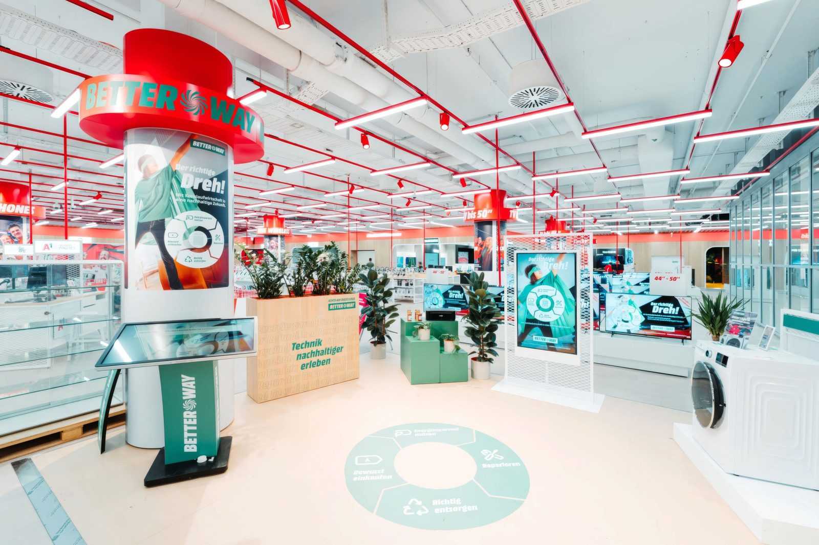 Megaholz store interior with Better Way sustainability campaign and eco-friendly tech displays.