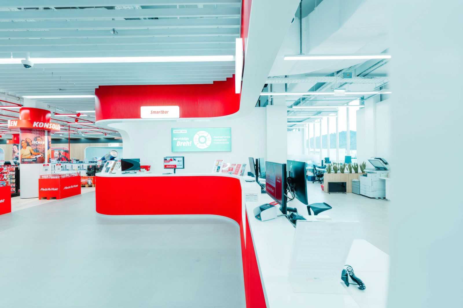 Modern Media Markt store interior with red Smartbar service desk.