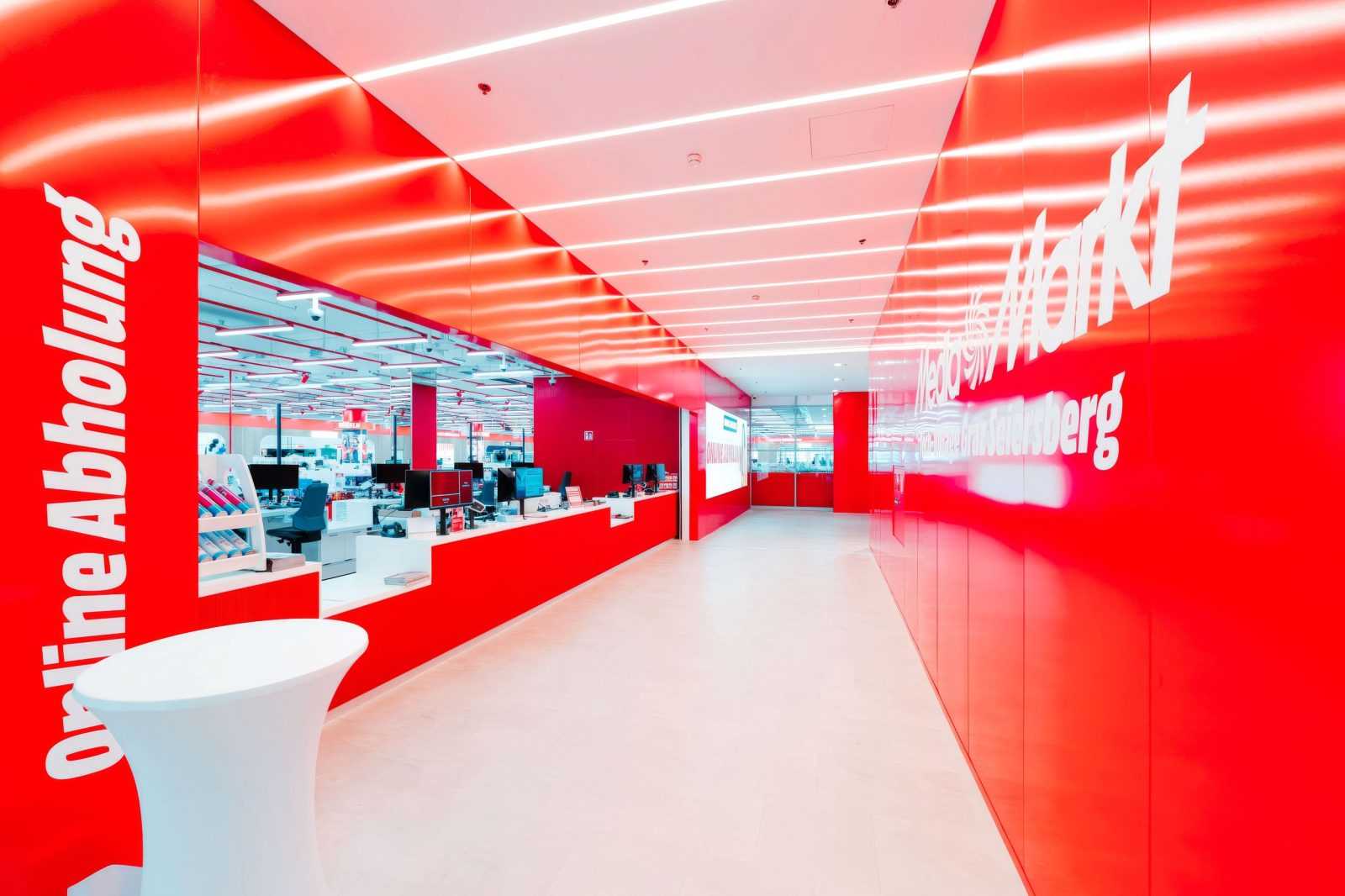 Media Markt store interior with red walls and online pickup sign.