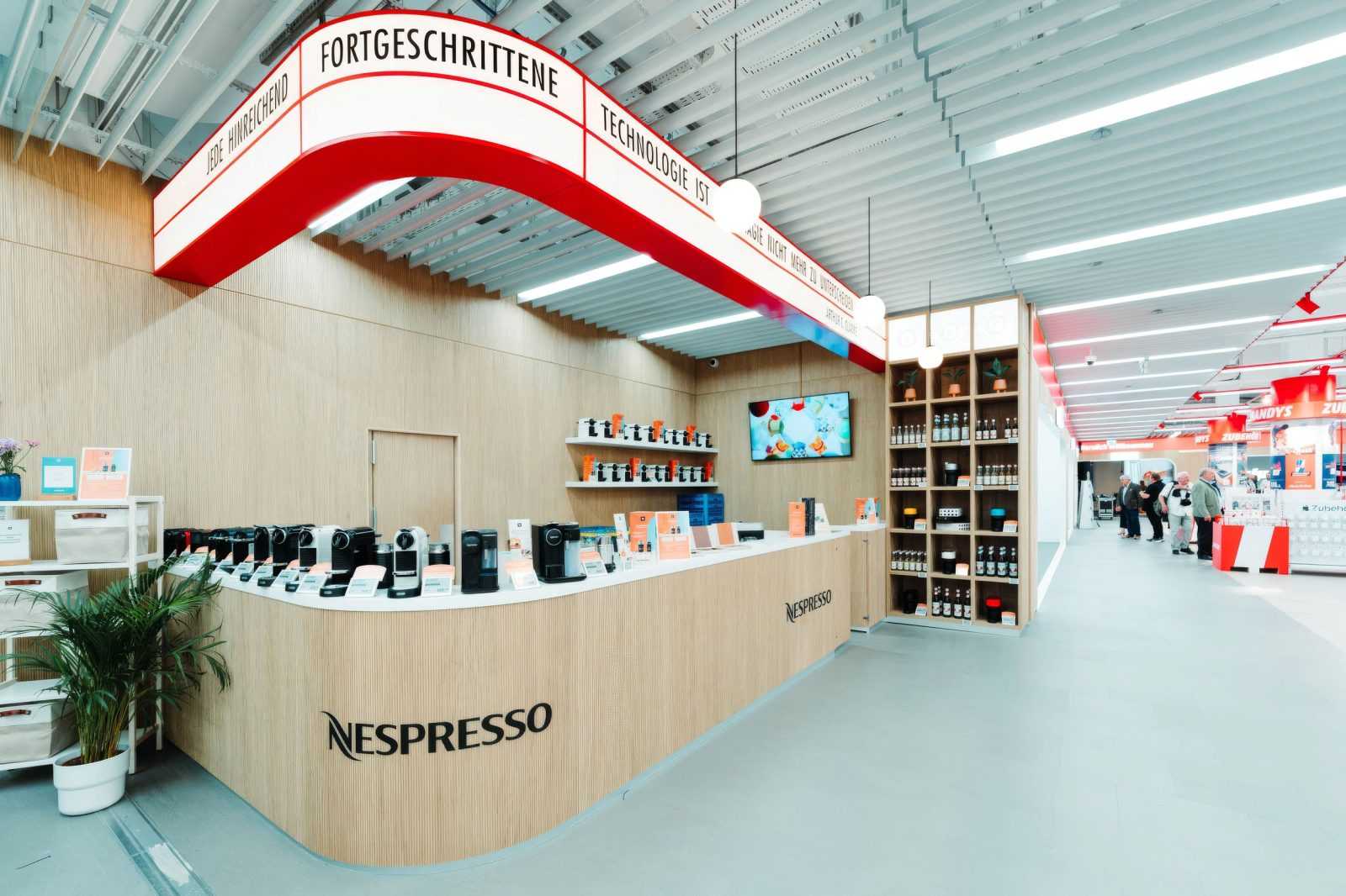 Nespresso kaffeeautomaten in modernem shop mit rotem design.