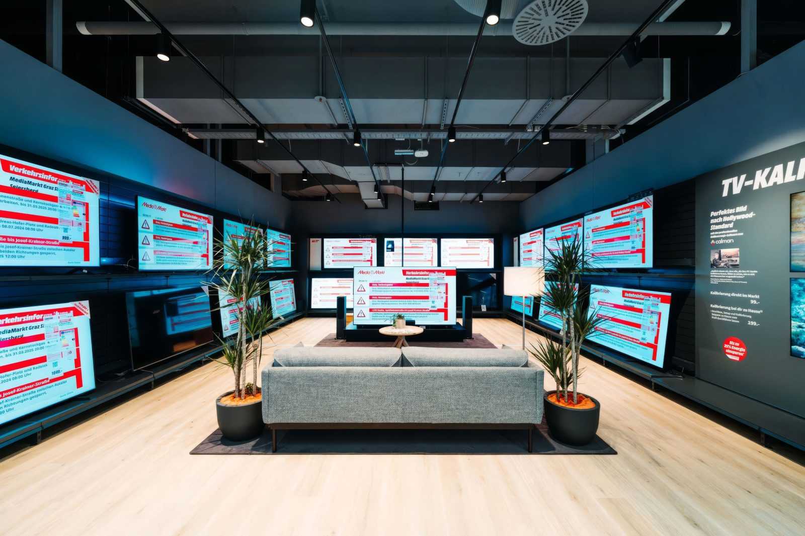 Modern TV showroom with multiple screens displaying traffic info at MediaMarkt Graz.