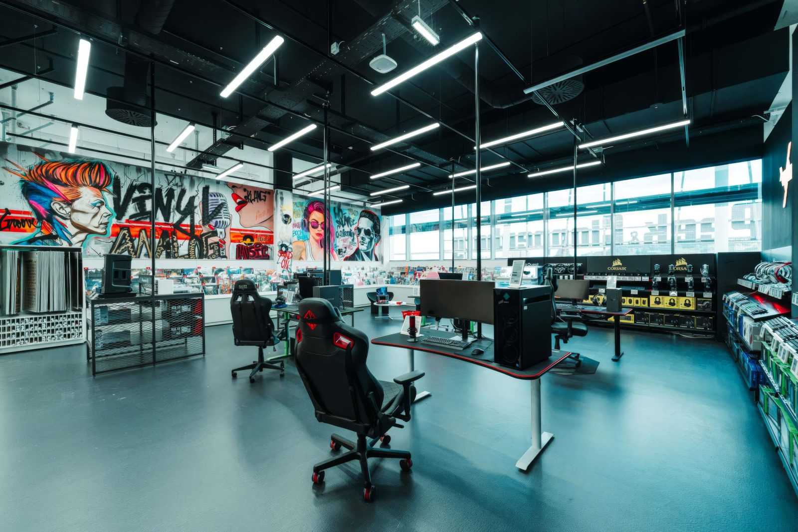 Modern gaming store interior with vibrant graffiti walls and gaming chairs.