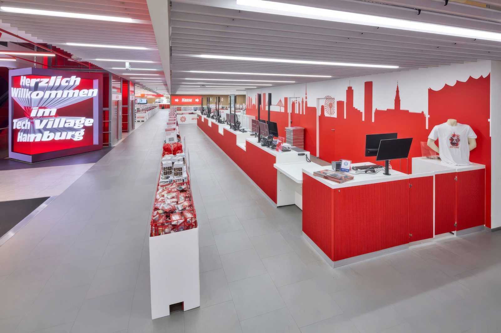 Welcome to Tech Village Hamburg - modern tech store interior with red and white design.